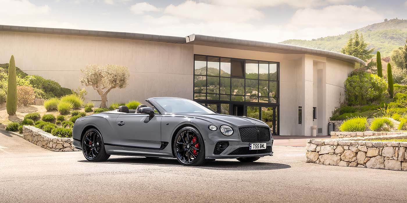 Bentley Knokke Bentley Continental GTC S convertible in Cambrian Grey paint front 34 static near house